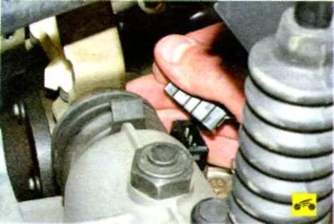 Сожмите пружинный фиксатор колодки жгута проводов и отсоедините колодку отдатчика скорости