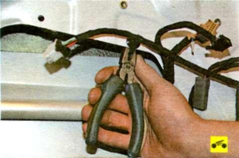 Отсоедините держатели жгута проводов от внутренней панели передней двери