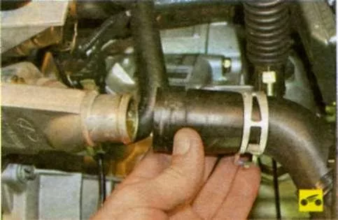 снимите с патрубка корпуса термостата подводящий шланг радиатора системы охлаждения двигателя